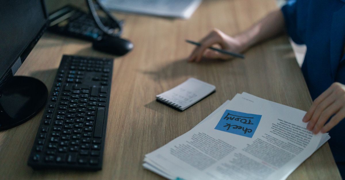 Profissional organiza currículo, perfil online e anotações para uma entrevista